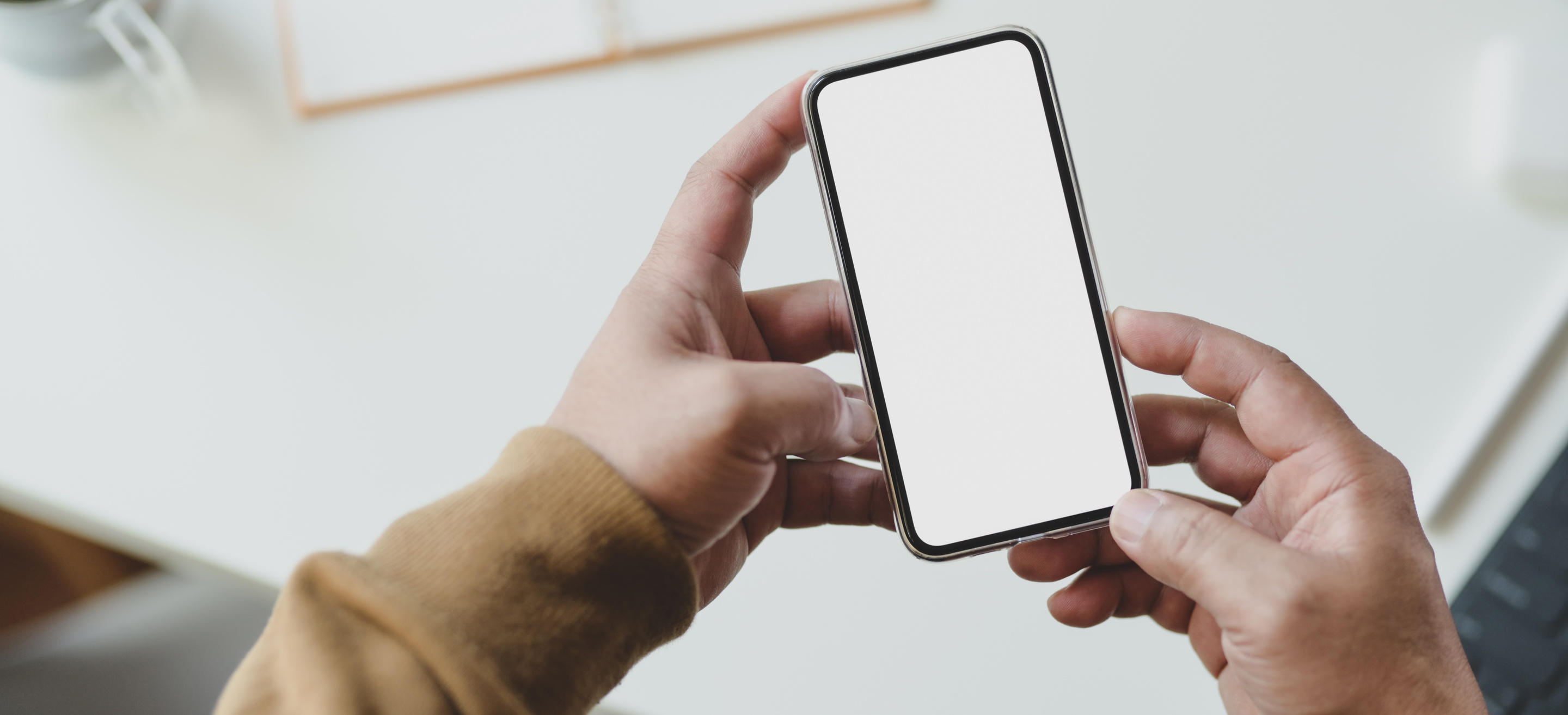 Person in Brown Sweater Holding Cellular Phone